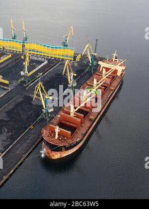 Murmansk, Russia - August 18, 2019: Vessels at the mooring of the coal terminal of the port of Murmansk. Shooting from above drone. Stock Photo