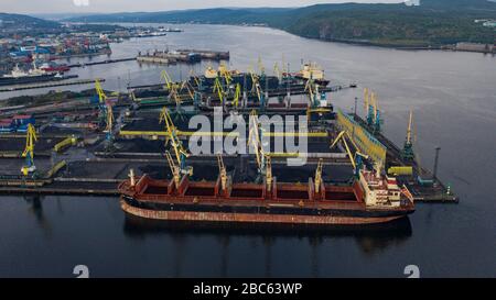 Murmansk, Russia - August 18, 2019: Vessels at the mooring of the coal terminal of the port of Murmansk. Shooting from above drone. Stock Photo