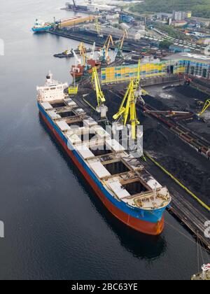 Murmansk, Russia - August 18, 2019: Vessels at the mooring of the coal terminal of the port of Murmansk. Shooting from above drone. Stock Photo