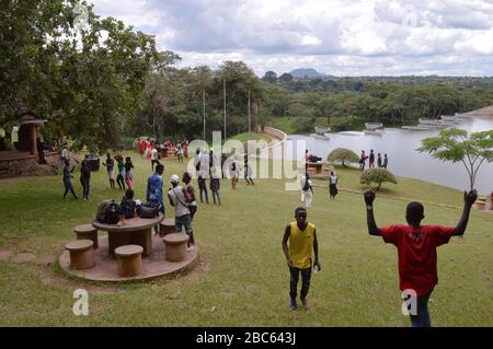 LILONGWE, MALAWI, AFRICA - APRIL 1, 2018: Two boys in yellow and red t-shirts near the the grass field of Kamuzu dam II, where african teenagers are h Stock Photo