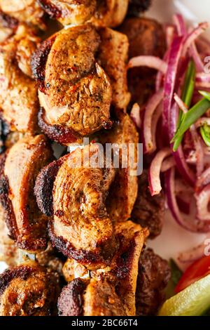 Traditional shashlik on a barbecue skewers with vegetables close up in restaurant. Keto or Paleo diet Stock Photo