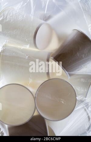 eco friendly disposable, compostable, recyclable paper cups in plastic bag. land pollution concept. suffocates nature Stock Photo