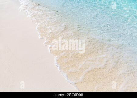 Soft beautiful ocean wave on sandy beach, tranquil shoreline Stock Photo