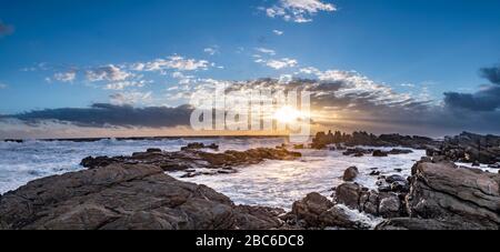 South Africa, Cape St Francis, Sun going down, over the Indian Ocean and the waves are pounding on the Rocks Stock Photo