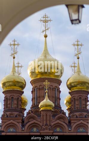 The Chernigovsky skete in Sergiev Posad, Russia, golden domes on the  huge belfry above the gate Stock Photo