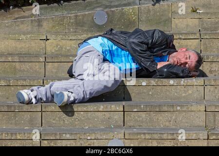 A man sleeps on the steps of Castle Square in Swansea, Wales, UK. Tuesday 31 March 2020 Stock Photo