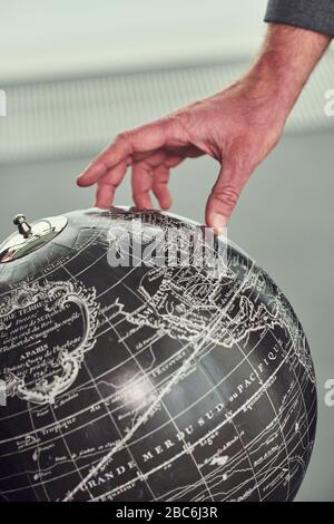 Hand scrolling on retro style world map Stock Photo