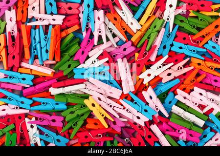 Small multi-colored clothespins as a full-screen texture and background. Decorative clothespins for creativity. The view from the top Stock Photo