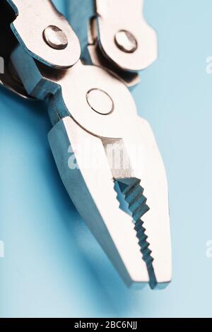 The multitool multi-function tool hovers on a blue background. The concept of an expanded multi-tool with free space. Clipping path included isolate Stock Photo