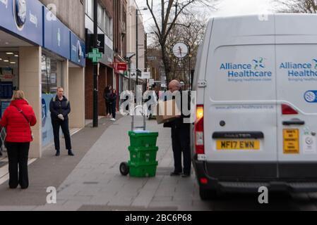 Brentwood Essex, UK. 3rd Apr, 2020. Larger numbers of cars and pedestrians in Brentwood High Street. during the covid lockdown. In particular large lines outside retail banks A pharmaceutical delivery Credit: Ian Davidson/Alamy Live News Stock Photo