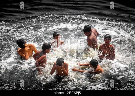 Dhaka, Bangladesh. 30th Mar, 2020. Some boys are playing in the black-polluted water of the Buriganga River. (Photo by Jahangir Alam/Pacific Press) Credit: Pacific Press Agency/Alamy Live News Stock Photo