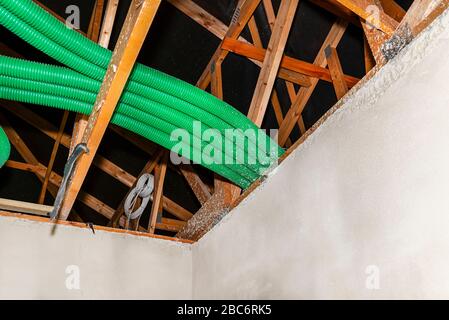 Home energy recovery ventilation, visible system of green flexible pipes for air transport, spread over the roof trusses. Stock Photo