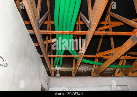 Home energy recovery ventilation, visible system of green flexible pipes for air transport, spread over the roof trusses. Stock Photo