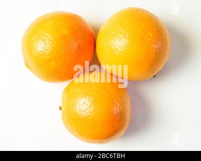 Three oranges from above on a white tablecloth Stock Photo