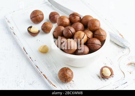 Plate with almonds in endocarp, whole and chopped open nuts in bulk Stock Photo