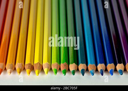 Close up still life of coloured pencils arranged in the colours of the rainbow. Stock Photo