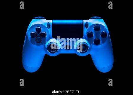 White video game joystick gamepad in blue neon lights isolated on a black background with clipping path Stock Photo