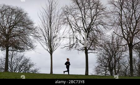 Glasgow, Scotland, UK. 3 April, 2020. Images from the southside of Glasgow at the end of the second week of Coronavirus lockdown. Pictured woman running alone in Queens Park.  Iain Masterton/Alamy Live News Stock Photo