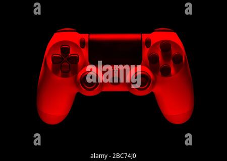 White video game joystick gamepad in red neon lights isolated on a black background with clipping path Stock Photo