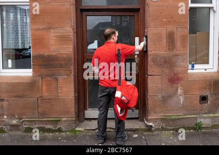 Glasgow, Scotland, UK. 3 April, 2020. Images from the southside of Glasgow at the end of the second week of Coronavirus lockdown. Pictured; Royal Mail postman making deliveries to tenement in Govanhill . Iain Masterton/Alamy Live News Stock Photo