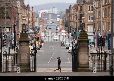 Glasgow, Scotland, UK. 3 April, 2020. Images from the southside of Glasgow at the end of the second week of Coronavirus lockdown.  Jogger runs past a very quiet Victoria Road in Govanhill.  Iain Masterton/Alamy Live News Stock Photo