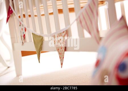 Close-up of a white children's bed with flags hanging on the bed Stock Photo