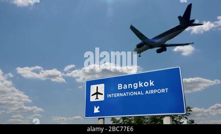 Airplane silhouette landing in Bangkok, Thailand. City arrival with international airport direction signboard and blue sky in background. Travel, trip Stock Photo