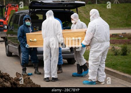 Undertakers wearing personal protective equipment carry the coffin during the funeral in the Eternal Gardens Muslim Burial Ground, Chislehurst of Ismail Mohamed Abdulwahab, 13, from Brixton, south London, who died alone in King’s College Hospital in the early hours of Monday after testing positive for the coronavirus. Stock Photo