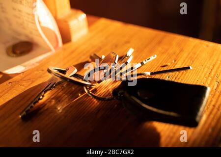 A group of keys on a wooden table at sunset Stock Photo