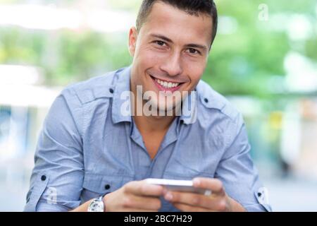 Young man using his smartphone Stock Photo