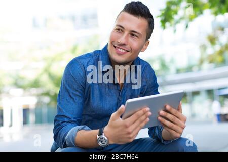 Young man with digital tablet outdoors Stock Photo