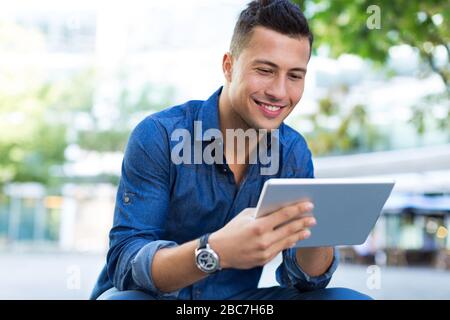 Young man with digital tablet outdoors Stock Photo