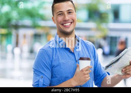 Man holding newspaper and coffee Stock Photo