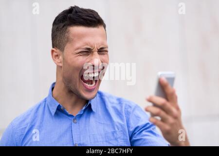 Man shouting at mobile phone Stock Photo