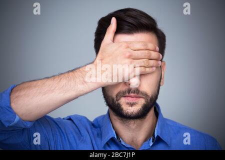 Man covering eyes Stock Photo