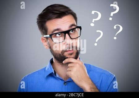 Man thinking with question marks Stock Photo
