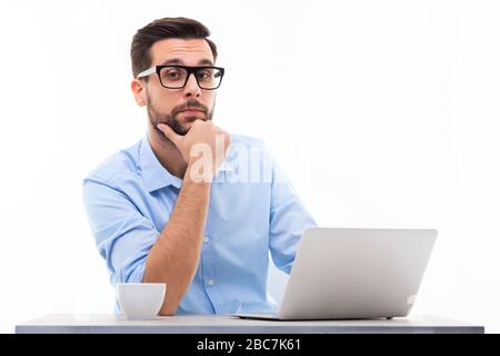 Young man at desk with laptop Stock Photo