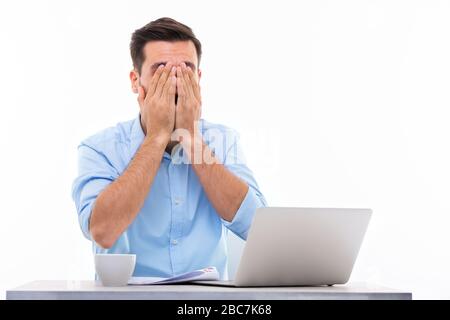 Young man at desk with laptop Stock Photo