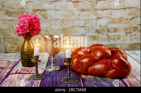 Traditional Jewish Sabbath Shalom ritual fresh challah bread with kiddush cup of red kosher wine Stock Photo