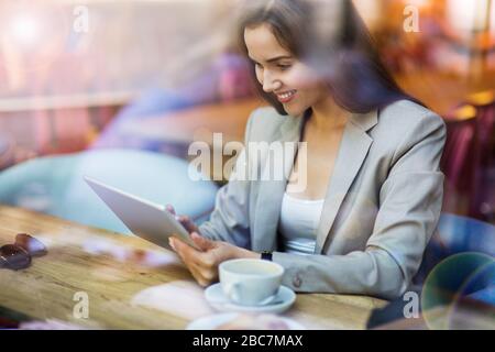 Young woman seen through cafe window Stock Photo