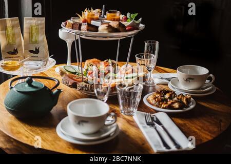 Wooden tabletop with traditional high tea, cake, fruits, sweets, dessert table at birthday party, baby shower party sweets. Stock Photo