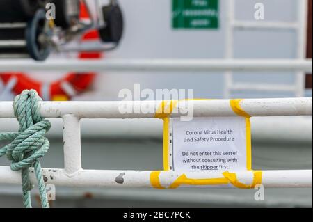 Castletownbere, West Cork, Ireland. 3rd Apr, 2020. A Coronavirus warning sign on a fishing vessel advises of contacting the skipper of the trawler before boarding the boat. Credit: Andy Gibson/Alamy Live News Stock Photo