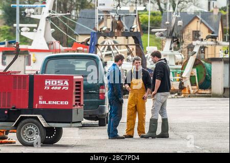 Castletownbere, West Cork, Ireland. 3rd Apr, 2020. Fishermen appear to ignore social distancing guidelines as they talk on the dock at Castletownbere. The government advises to keep a distance of 2 metres between people. Credit: Andy Gibson/Alamy Live News Stock Photo