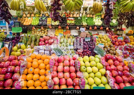 All kinds of fruits like apple, orange, banana, pear, kiwi, grapes, pomme de granate are displayed for sale in the local market Stock Photo