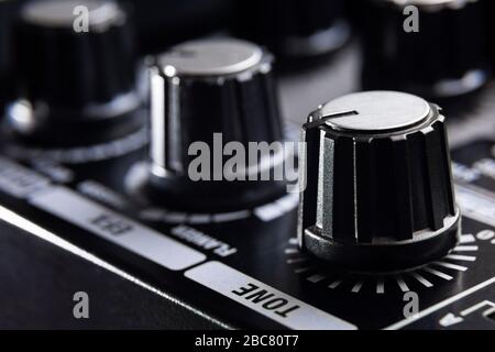 selective focus on the tone knob of an amplifier for electric musical instruments Stock Photo