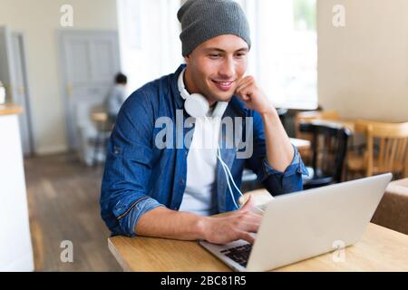 Young man using laptop at cafe Stock Photo