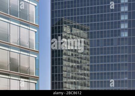 Office building with reflections in glass facade of another building Stock Photo