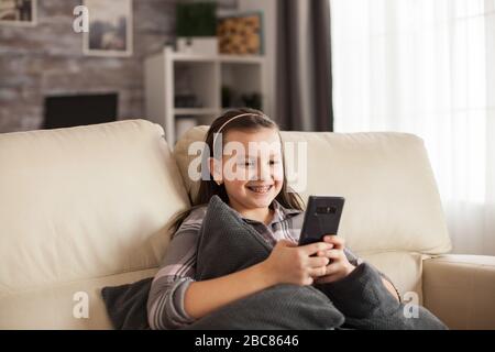 Excited young girl with a big smile and braces browsing on smartphone. Stock Photo