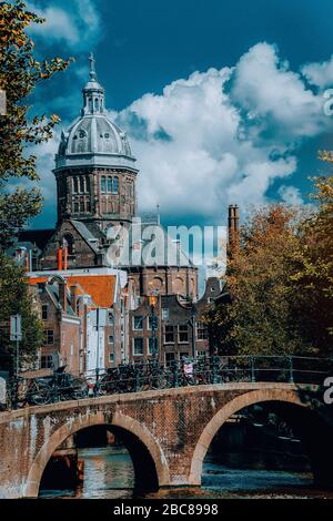 St. Nicholas Church in Amsterdam against white clouds at autumn sunny day. Amazing vibrant scenery Holland, Netherlands Stock Photo