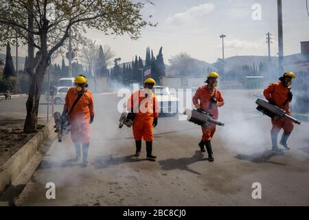 The Iranian health ministry, provincial fire department and municipal staffs disinfect the streets and other public places against Coronavirus(Covid-19) using machinery and mobile pumps in Shiraz, Fars province, Iran. April, 2020. Stock Photo